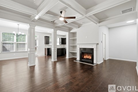 A spacious living room with a fireplace and wooden floors.