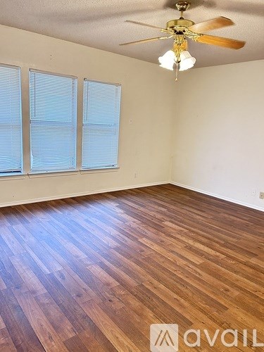 A room with wooden flooring and a ceiling fan.