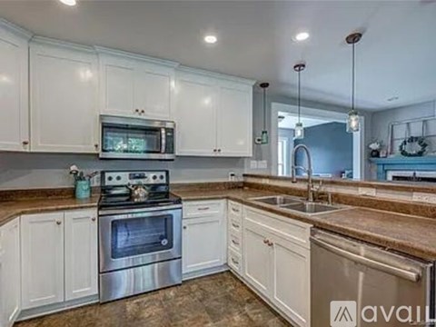 A kitchen with white cabinets and a granite countertop.