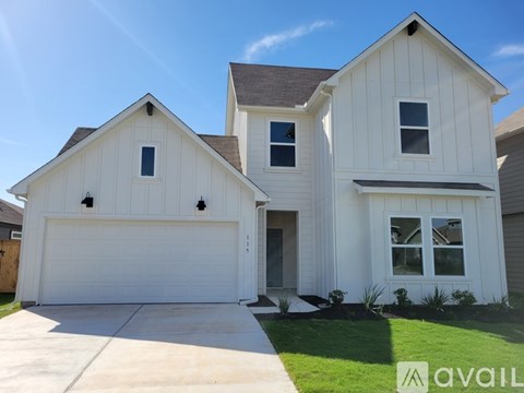 A two-story house with a white garage door is for sale.
