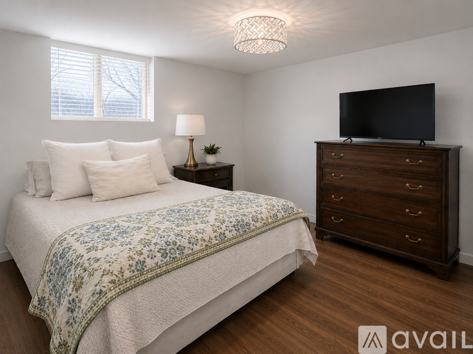 A bedroom with a bed, nightstand, and a television.
