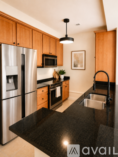 A kitchen with a black granite countertop and wooden cabinets.