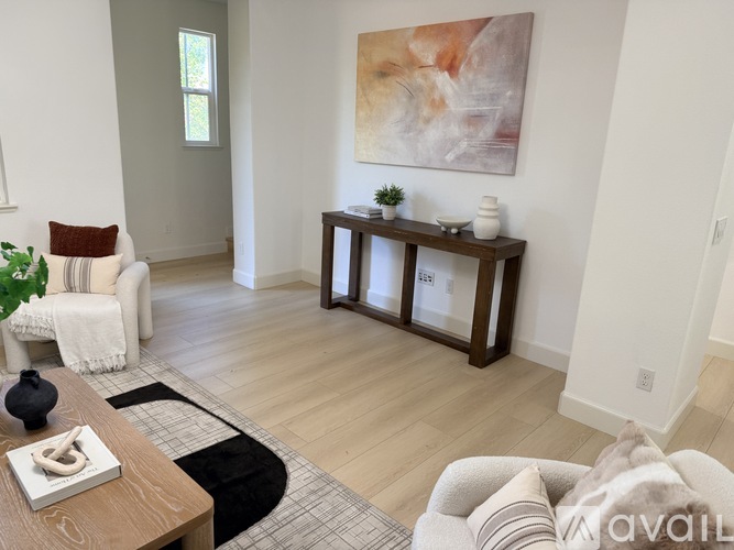 A living room with a brown coffee table and a white chair.