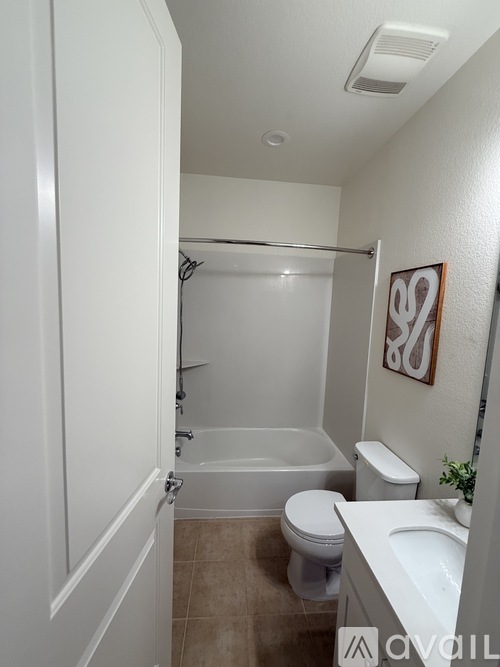 A bathroom with a toilet, sink, and bathtub.