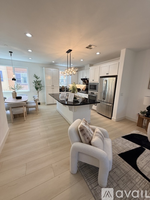 A modern kitchen with a dining area and a living room.
