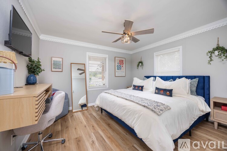 A bedroom with a large bed and a ceiling fan.