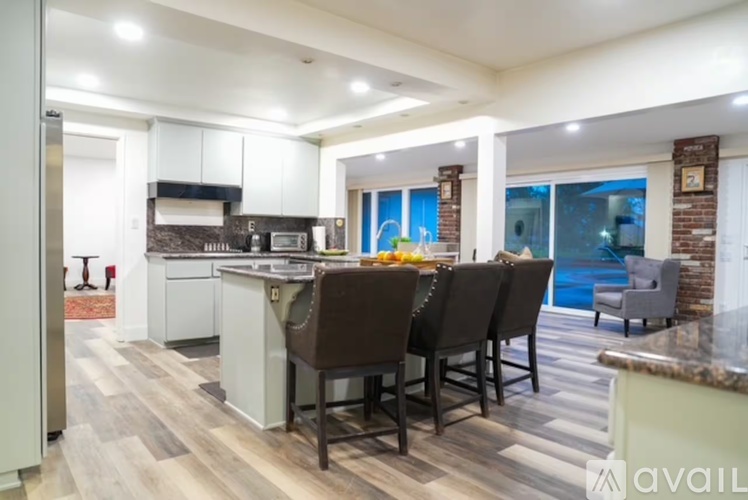 A modern kitchen with a dining table and chairs.