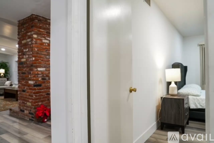 A bedroom with a brick fireplace and a bed with a white pillow.