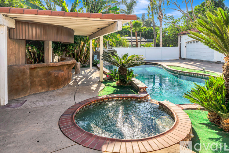 A backyard with a pool and a hot tub.