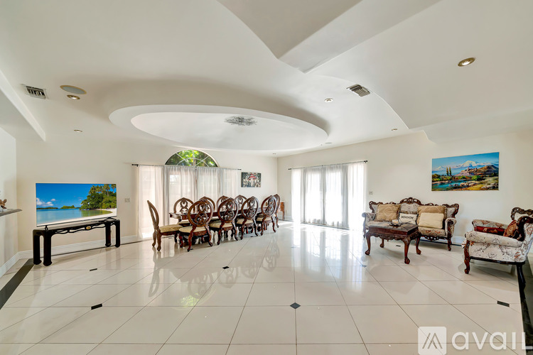A living room with a white ceiling and a painting of a beach scene on the wall.
