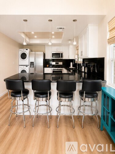 A kitchen with black chairs and a black counter.