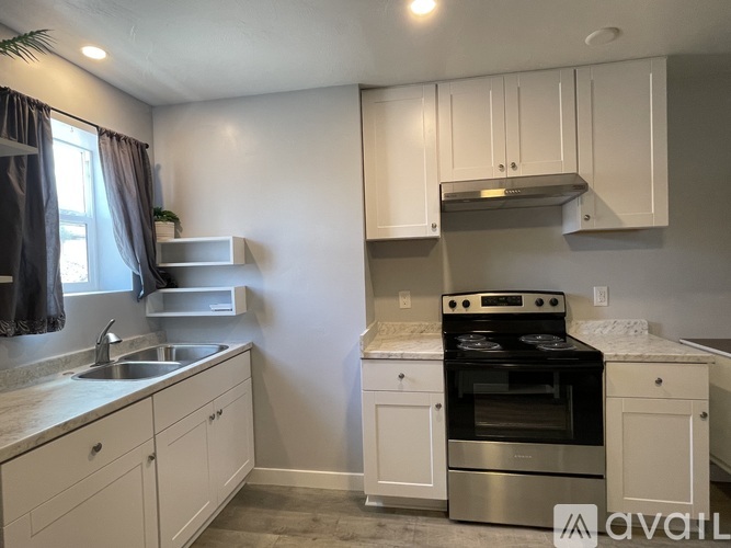 A kitchen with a stove top oven and a sink.