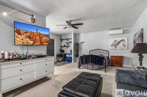A living room with a flat screen TV mounted on the wall.
