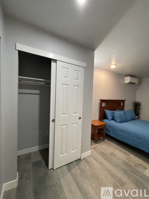 A bedroom with a patterned bedspread and a ceiling fan.