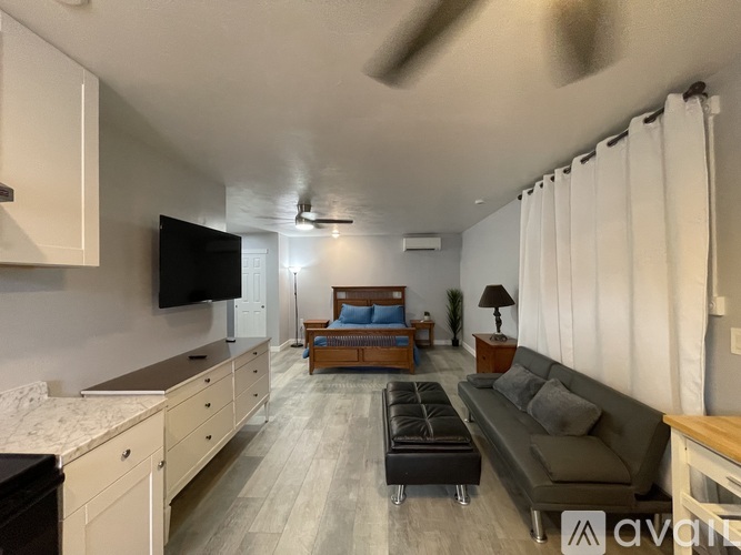 A bathroom with a white tub, sink, and toiletries.