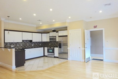 A kitchen with a black counter top and white cabinets.