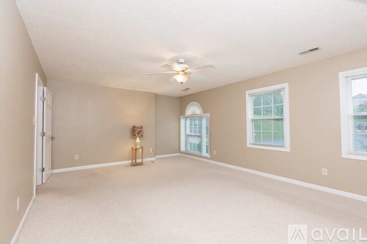 A spacious room with a ceiling fan and a window.