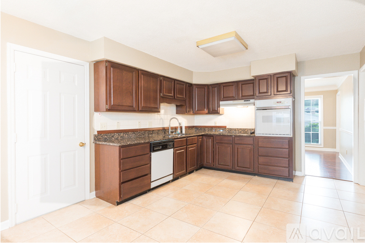 A kitchen with brown cabinets and a white door.