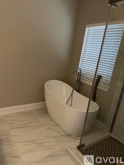 A bathroom with a white tub and a glass shower door.