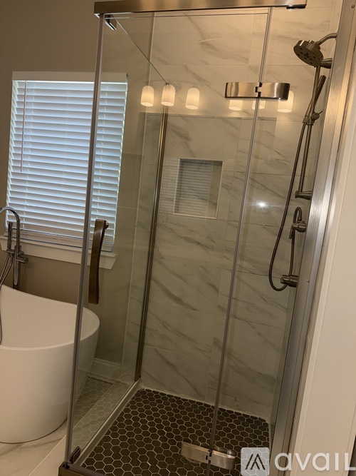 A bathroom with a walk-in shower and a white bathtub.