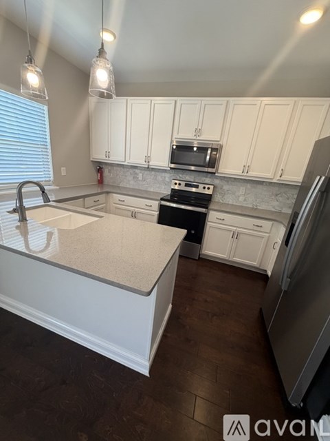 A kitchen with white cabinets and a granite countertop.