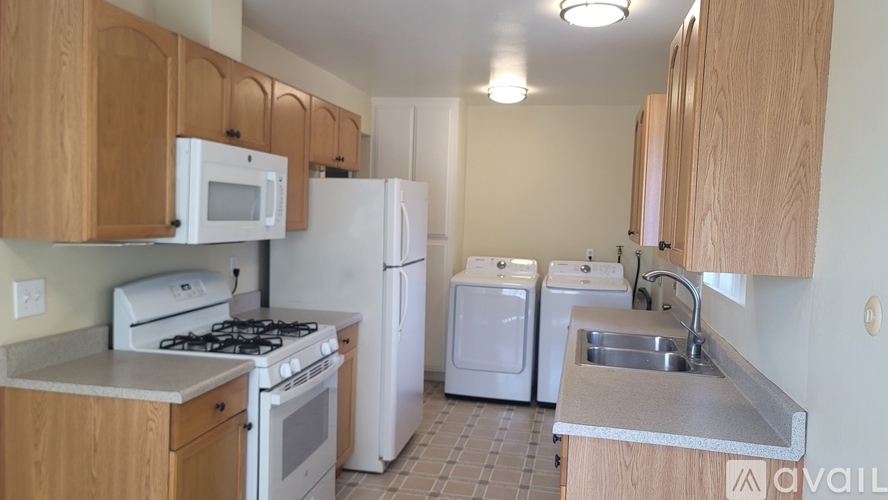 A kitchen with a stove, refrigerator, and microwave.