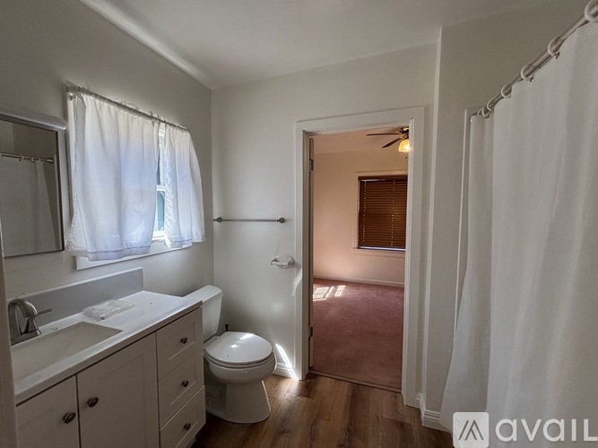 A bathroom with a toilet, sink, and shower.