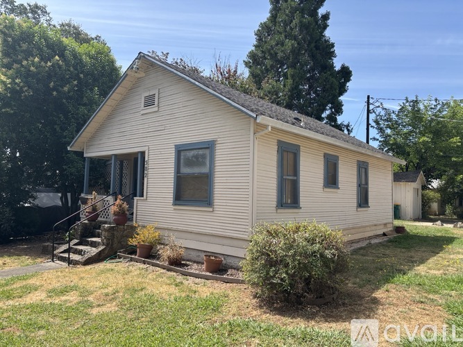 A small house with a porch and a front yard.