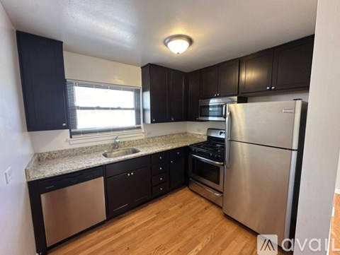 A kitchen with black cabinets and stainless steel appliances.