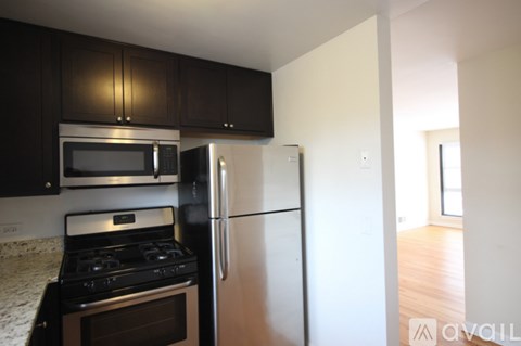 A kitchen with a stove, oven, microwave and refrigerator.