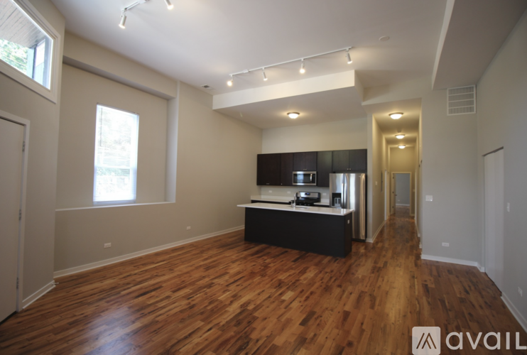 A spacious room with wooden floors and a large window.