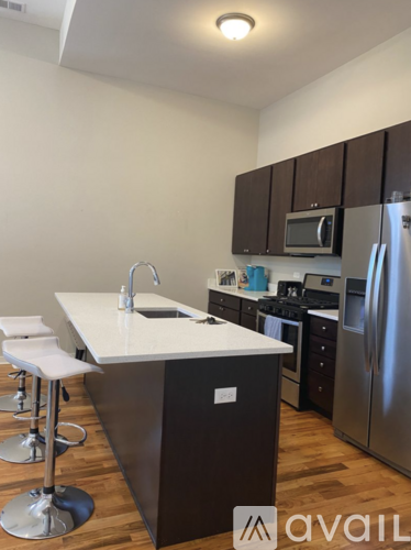 A kitchen with a white counter top and stainless steel appliances.