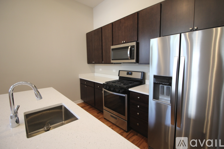 A kitchen with a stainless steel refrigerator, sink, and cabinets.