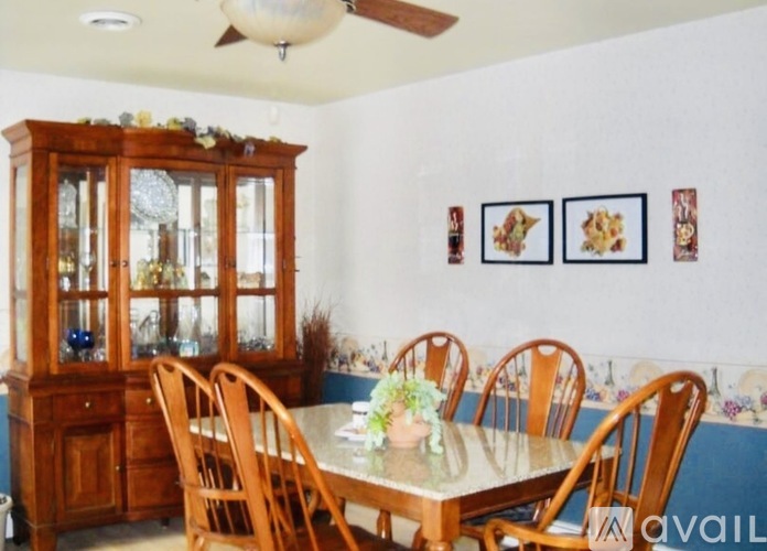 A dining room with a wooden table and chairs.