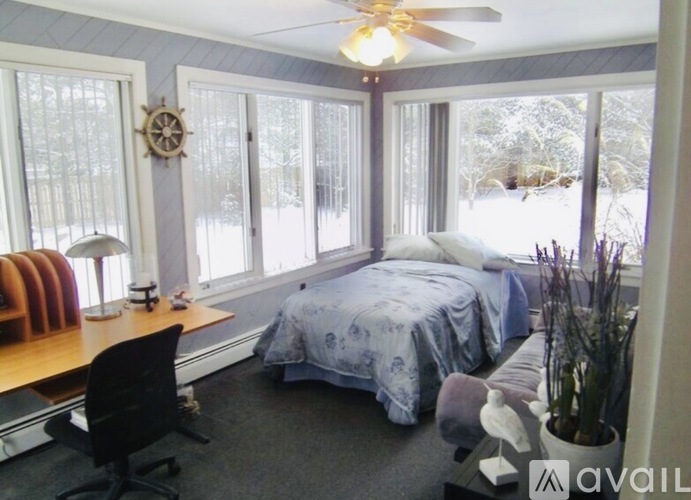 A bedroom with a bed, desk, and chair.