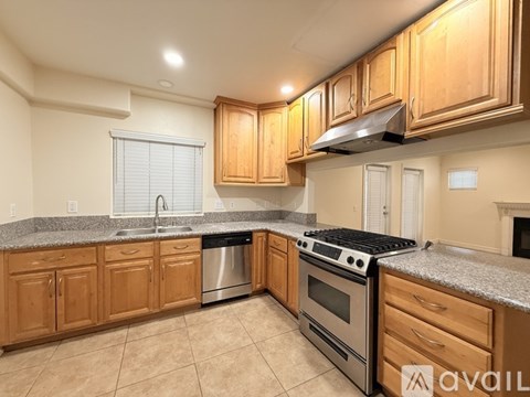 A kitchen with wooden cabinets and granite countertops.