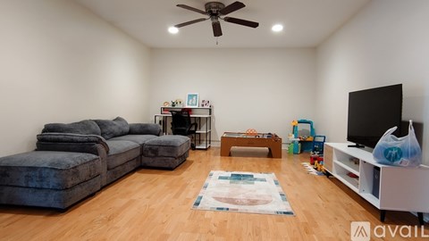 A living room with a blue sofa, a television, and a rug on the floor.