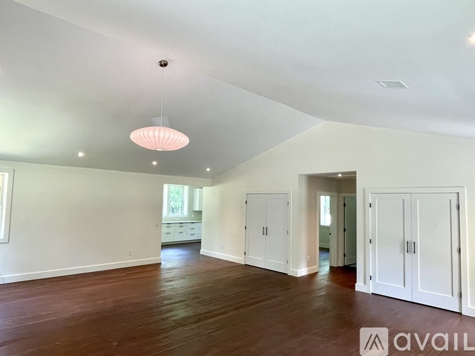 A spacious room with wooden floors and white walls.