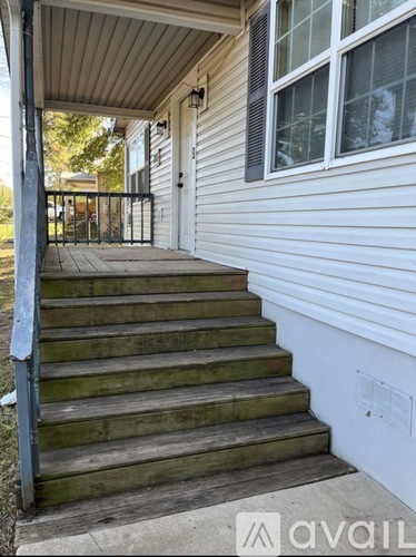 A set of wooden stairs leading up to a door.
