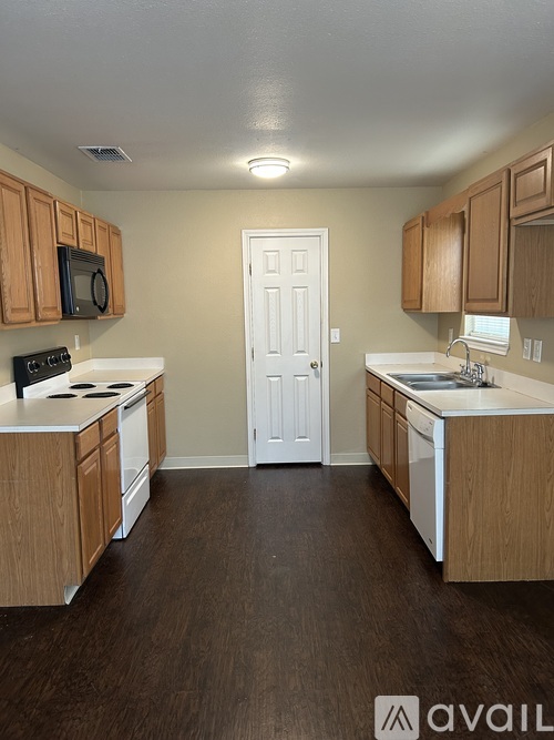 A kitchen with wooden cabinets and a white door.