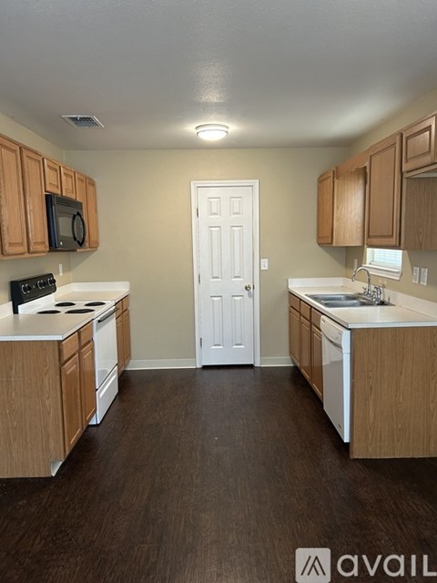 A kitchen with wooden cabinets and a white door.