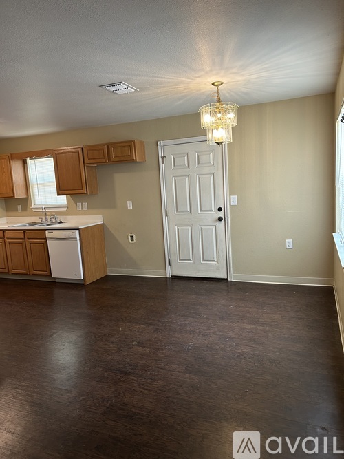 A kitchen with brown floors and a white door.