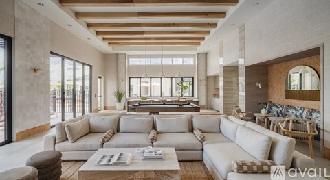 A spacious living room with a large sectional sofa and a coffee table in the center.