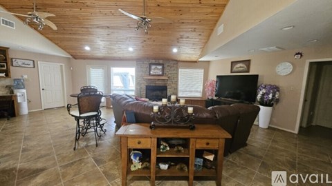 A living room with a brown couch, a wooden table, and a television.