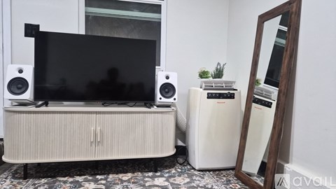 A white TV stand with a flat screen TV and two speakers on it.