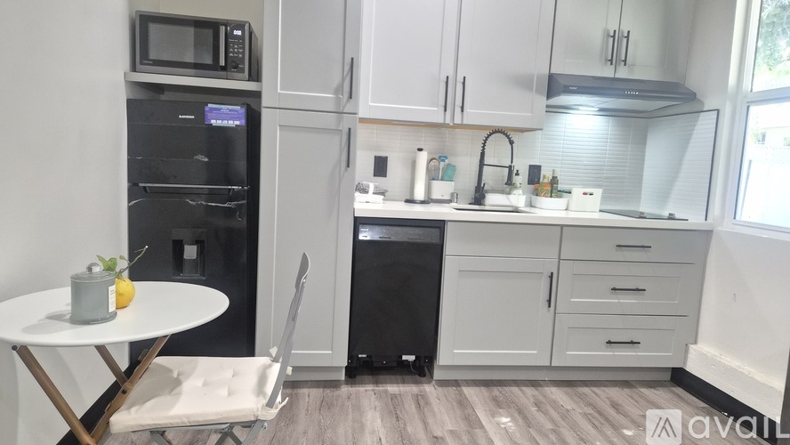 A kitchen with a table and chairs and a fridge.