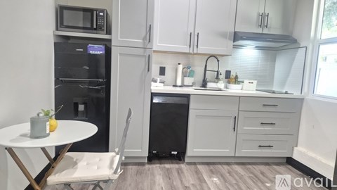 A kitchen with a table and chairs and a fridge.
