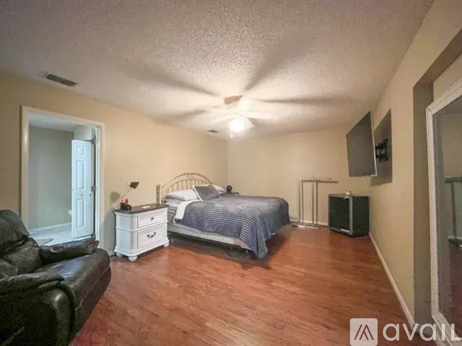 A bedroom with a bed, dresser, and chair.
