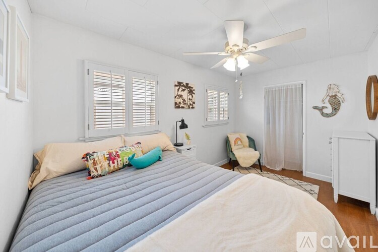 A bedroom with a large bed and a ceiling fan.