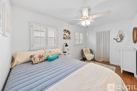A bedroom with a large bed and a ceiling fan.
